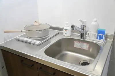 a kitchen sink with a pan on top of it at Tokyo Time Traveler \u99c5\u5f92\u6b695\u5206 \u66ae\u3089\u3059\u3088\u3046\u306b\u6cca\u307e\u308c\u308b\u30db\u30c6\u30eb in Tokyo