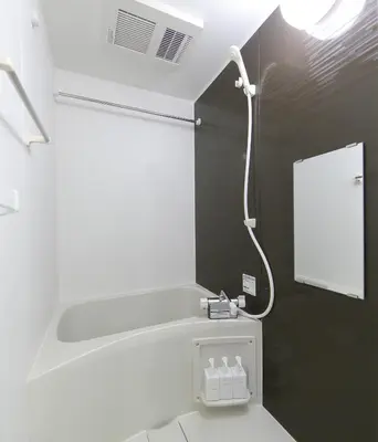 a bathroom with a toilet with a light on the wall at Tokyo Time Traveler \u99c5\u5f92\u6b695\u5206 \u66ae\u3089\u3059\u3088\u3046\u306b\u6cca\u307e\u308c\u308b\u30db\u30c6\u30eb in Tokyo