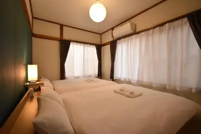 a bedroom with two beds and a window at \u30a2\u30f3\u30c9\u30b9\u30c6\u30a4\u6587\u82b11\u4e01\u76ee in Tokyo