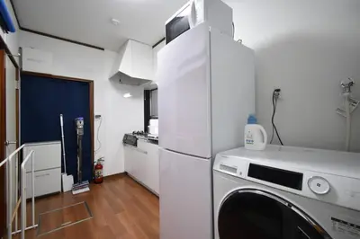a kitchen with a refrigerator and a washing machine at \u30a2\u30f3\u30c9\u30b9\u30c6\u30a4\u6587\u82b11\u4e01\u76ee in Tokyo