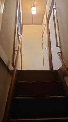a stairway leading up to a hallway with a door at \u30a2\u30f3\u30c9\u30b9\u30c6\u30a4\u6587\u82b11\u4e01\u76ee in Tokyo