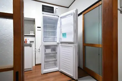 a refrigerator with its door open in a kitchen at \u30a2\u30f3\u30c9\u30b9\u30c6\u30a4\u6587\u82b11\u4e01\u76ee in Tokyo