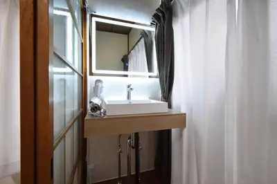 a bathroom with a sink and a mirror next to a shower at \u30a2\u30f3\u30c9\u30b9\u30c6\u30a4\u6587\u82b11\u4e01\u76ee in Tokyo