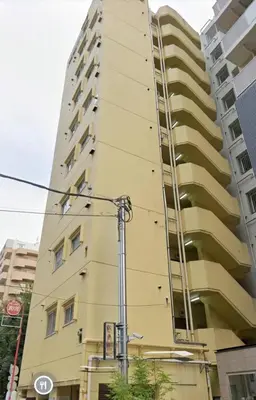 a tall building with a ladder on the side of it at CowCow Hotel Shinjuku in Tokyo
