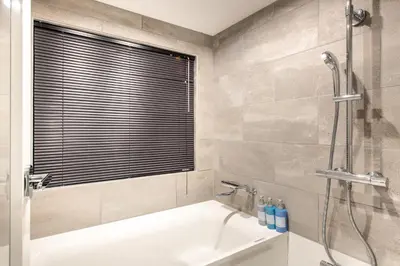 a bathroom with a shower and a bath tub at NEXUS HOTEL Gotanda in Tokyo