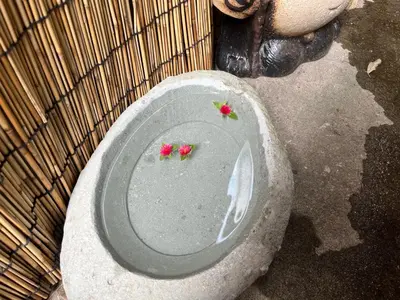 a stone toilet with flowers on top of it at SUZUNONE The only private lodging in Tokyo 2 min walk natural hot springs near BIG super market ASAKUSA AKIHABARA SKYTREE nearby Japanese TATAMI style 70m2 in Tokyo