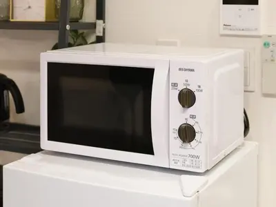 a white microwave oven sitting on top of a counter at Oyama pantheon in Tokyo