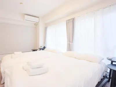 a white bedroom with a large white bed with towels on it at Oyama pantheon in Tokyo