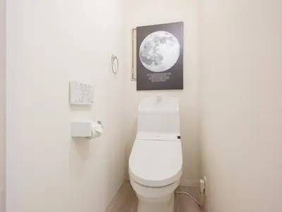 a bathroom with a toilet and a picture of the moon at Oyama pantheon in Tokyo