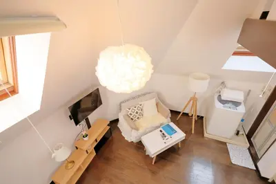 a small attic room with a bed and a lamp at Mi-LOFT SHIBUYA in Tokyo