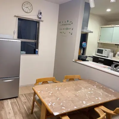 a kitchen with a table and chairs and a refrigerator at MiShe\u4e3b\u9898\u5357\u884c\u5fb3\u6c11\u5bbf in Tokyo