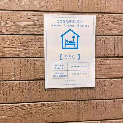 a sign for a building on a wooden wall at MiShe\u4e3b\u9898\u5357\u884c\u5fb3\u6c11\u5bbf in Tokyo