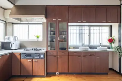 a kitchen with wooden cabinets and a stove top oven at SKY GATEスカイツリー徒歩3分の貸切ヴィラ/成田羽田直通/浅草徒歩15分 in Tokyo