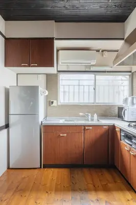 a kitchen with wooden cabinets and a refrigerator at SKY GATEスカイツリー徒歩3分の貸切ヴィラ/成田羽田直通/浅草徒歩15分 in Tokyo