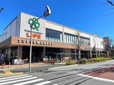 a building with a supermarket sign in front of a street at Gest Residence EDORIVER Airport Line Self check in in Tokyo