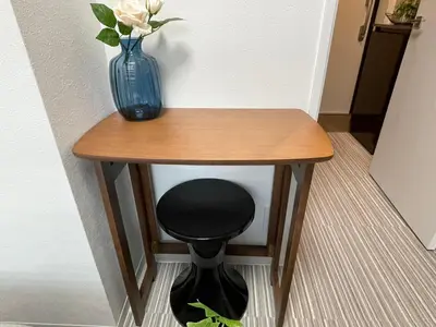a small table with a blue vase and a stool at COMMA HOUSE Shinjuku 2UNITS 2324 in Tokyo