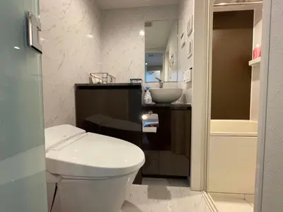 a bathroom with a white toilet and a sink at COMMA HOUSE Shinjuku 2UNITS 2324 in Tokyo