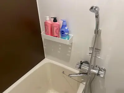 a bathroom with a sink and a shower with bottles at COMMA HOUSE Shinjuku 2UNITS 2324 in Tokyo