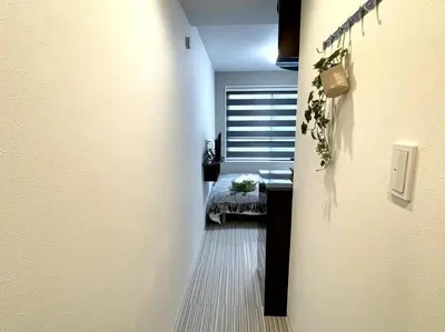 a hallway with a room with a bed and a window at COMMA HOUSE Shinjuku 2UNITS 2324 in Tokyo