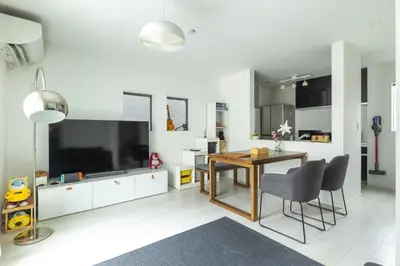 a living room with a table and a large television at HAN Tokyo in Tokyo