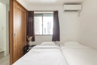 two beds in a room with a window at HAN Tokyo in Tokyo