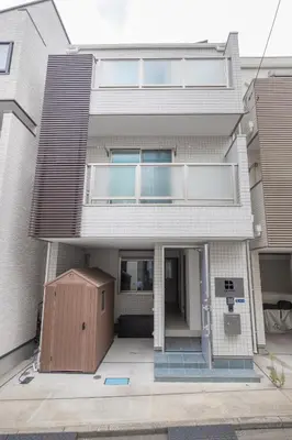 a white house with a brown door in front of it at HAN Tokyo in Tokyo