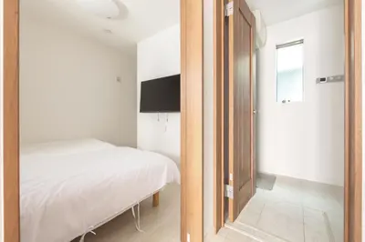 a bedroom with a bed and a mirror at HAN Tokyo in Tokyo
