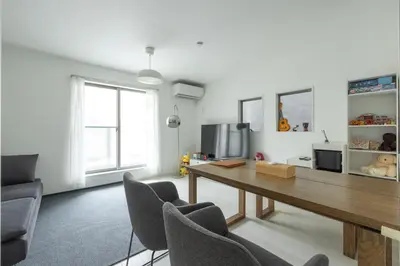 a living room with a wooden table and chairs at HAN Tokyo in Tokyo
