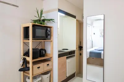 a small room with a tv and a mirror at Kaku Studio Apartment Ikebukuro in Tokyo