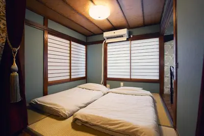 two beds in a room with two windows at Retro Style Japanese House 10-min walk to Asakusa in Tokyo