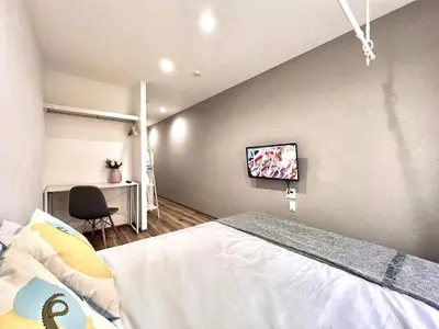 a bedroom with a bed and a tv on the wall at ANX Hostel-AD0080 in Tokyo