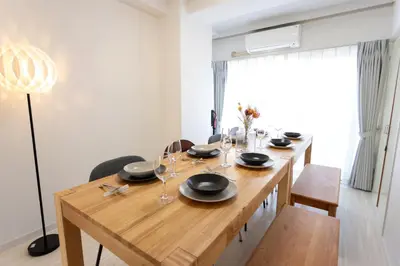 a dining room with a wooden table with glasses on it at Kamata Smile House - \u84b2\u7530\u3059\u307e\u3044\u308b\u30cf\u30a6\u30b9 in Tokyo