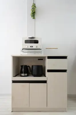 a kitchen with a white counter top with a microwave at Kamata Smile House - \u84b2\u7530\u3059\u307e\u3044\u308b\u30cf\u30a6\u30b9 in Tokyo