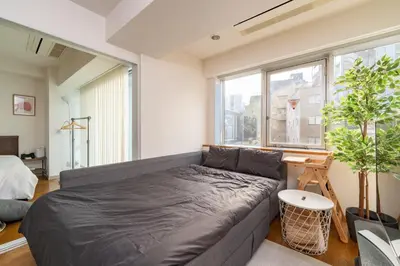 a living room with a couch and a window at CoCoHouse Asakusa - SkyTree View, 72\u33a1 in Tokyo