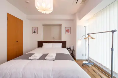 a bedroom with a large bed with two towels on it at CoCoHouse Asakusa - SkyTree View, 72\u33a1 in Tokyo
