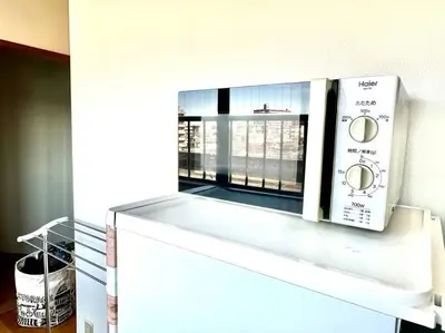 a microwave oven sitting on top of a refrigerator at Tokyo House2 Best location in JUJO 2minutes walk to JR Jujo station in Tokyo
