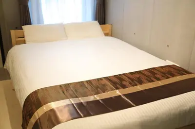 a bed in a room with a white bedsheet and a window at [Newly built condominium for rent! ] 5 minutes wal - Vacation STAY 98142v in Tokyo