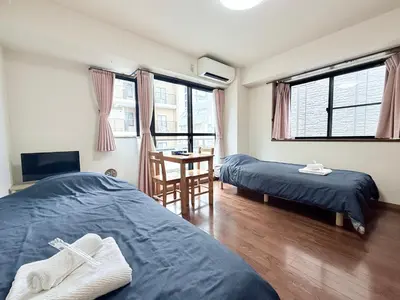 a bedroom with two beds and a table with a chair at \u30db\u30c6\u30eb\u30b5\u30f3\u30af\u30ea\u30b9\u30bf\u30fc #404 in Tokyo