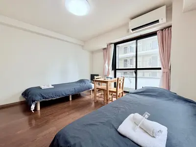 a room with two beds and a table and a window at \u30db\u30c6\u30eb\u30b5\u30f3\u30af\u30ea\u30b9\u30bf\u30fc #404 in Tokyo