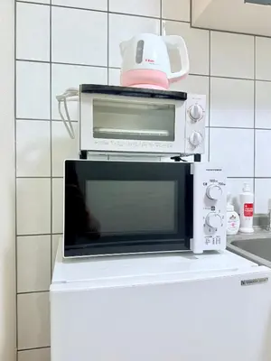 a microwave oven sitting on top of a refrigerator at \u30db\u30c6\u30eb\u30b5\u30f3\u30af\u30ea\u30b9\u30bf\u30fc #404 in Tokyo