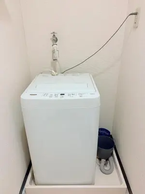 a white washing machine in a bathroom with a cord at \u30db\u30c6\u30eb\u30b5\u30f3\u30af\u30ea\u30b9\u30bf\u30fc #404 in Tokyo