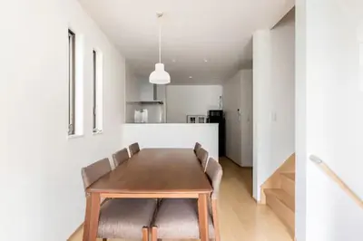 a dining room with a wooden table and chairs at SkyTreeHotel\u30fc\u6d45\u8349\u307e\u3067\u96fb\u8eca\u4e57\u8eca7\u5206\u3067\u30b9\u30ab\u30a4\u30c4\u30ea\u30fc\u307e\u3067\u96fb\u8eca\u4e57\u8eca3\u5206\u3055\u3089\u306b\u7a7a\u6e2f\u304b\u3089\u76f4\u901a\u3067\u305912\u540d\u307e\u3067\u306e\u4e00\u8ed2\u5bb6\u306e3LDK\u306e7\u5e74\u3067\u7dba\u9e97\u99d0\u8eca\u5834\u4ed8 in Tokyo