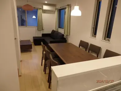 a living room with a table and chairs and a couch at SkyTreeHotel\u30fc\u6d45\u8349\u307e\u3067\u96fb\u8eca\u4e57\u8eca7\u5206\u3067\u30b9\u30ab\u30a4\u30c4\u30ea\u30fc\u307e\u3067\u96fb\u8eca\u4e57\u8eca3\u5206\u3055\u3089\u306b\u7a7a\u6e2f\u304b\u3089\u76f4\u901a\u3067\u305912\u540d\u307e\u3067\u306e\u4e00\u8ed2\u5bb6\u306e3LDK\u306e7\u5e74\u3067\u7dba\u9e97\u99d0\u8eca\u5834\u4ed8 in Tokyo