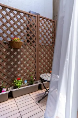 a wooden privacy fence with a table and potted plants at \u4e21\u56fd\u99c5\u524d in Tokyo
