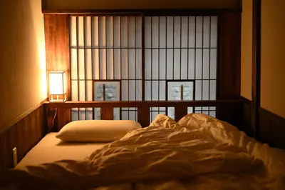 an unmade bed in a room with a window at Hotel Suzumeya Tsukiji \u30db\u30c6\u30eb\u3059\u305a\u3081\u3084\u7bc9\u5730 in Tokyo