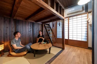 a man and a woman sitting at a table in a room at Hotel Suzumeya Tsukiji \u30db\u30c6\u30eb\u3059\u305a\u3081\u3084\u7bc9\u5730 in Tokyo