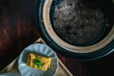 a piece of food on a plate next to a bowl of beans at Hotel Suzumeya Tsukiji \u30db\u30c6\u30eb\u3059\u305a\u3081\u3084\u7bc9\u5730 in Tokyo