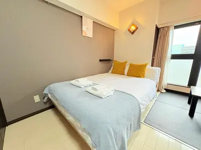 two twin beds in a room with a window at Arche de Reve in Tokyo