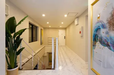 a hallway with a staircase and a potted plant at \u8fd1\u79cb\u53f6\u539f\u4e1c\u4eac\u7ad9 \u8d85\u5962\u534e\u4e09\u5367\u5957\u623fKFoa \u5730\u94c12\u5206\u949f 4\u7ad9\u4ea4\u6c47 \u9876\u7ea7\u6234\u68ee\u5439\u98ce \u6700\u59278\u4eba in Tokyo