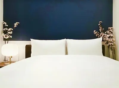 a white bed with white pillows and a blue wall at \u8fd1\u79cb\u53f6\u539f\u4e1c\u4eac\u7ad9 \u8d85\u5962\u534e\u4e09\u5367\u5957\u623fKFoa \u5730\u94c12\u5206\u949f 4\u7ad9\u4ea4\u6c47 \u9876\u7ea7\u6234\u68ee\u5439\u98ce \u6700\u59278\u4eba in Tokyo
